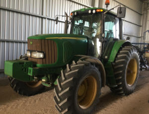 A John Deere 7420 mechanical front-wheel drive tractor A John Deere tractor parked in a shed